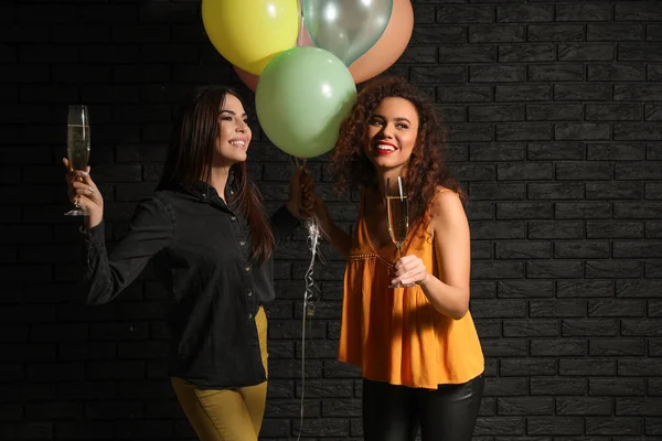 Beautiful Young Women Balloons Glasses Champagne Dark Brick Wall — Stock Photo, Image