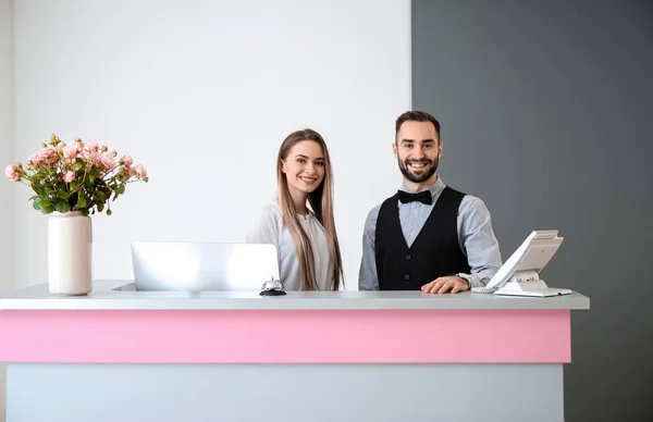 Male and female receptionists at desk in hotel