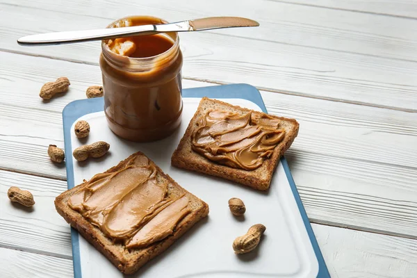 Pão Torrado Com Manteiga Amendoim Saborosa Mesa Madeira Branca — Fotografia de Stock