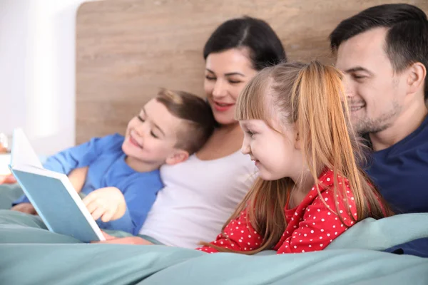 快乐的家庭在卧室里看书 — 图库照片
