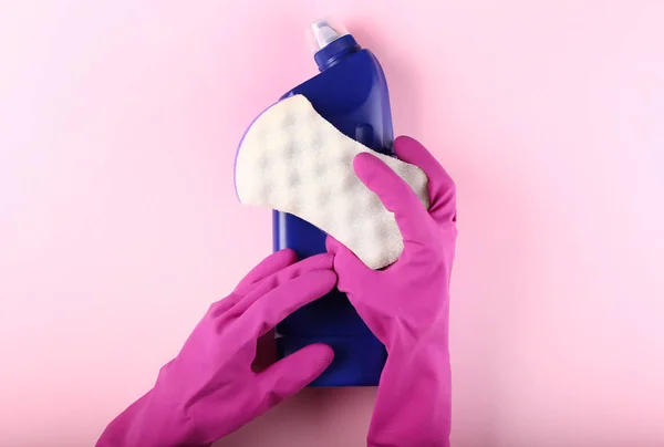 スポンジと洗剤の色の背景に女性用務員の手 — ストック写真