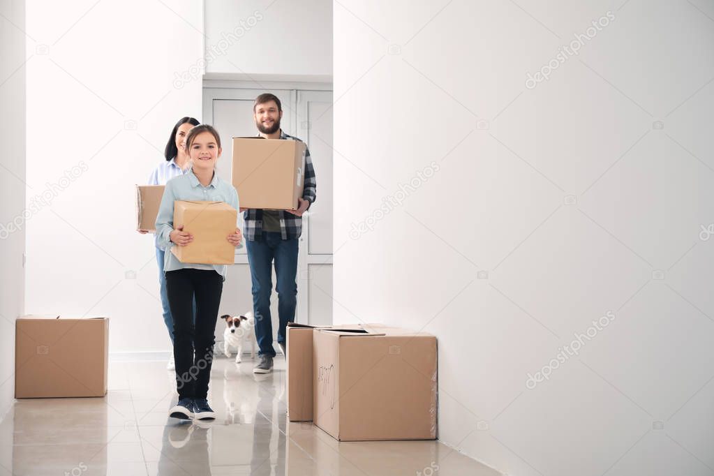 Family with cardboard boxes moving into new house