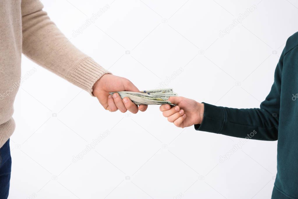 Man giving money to his son on light background. Concept of child support
