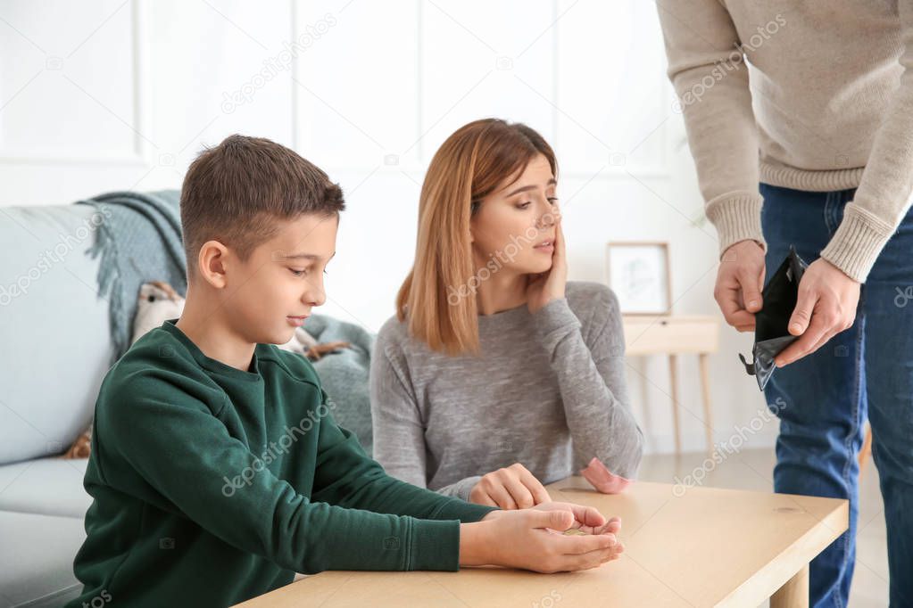 Poor man showing his ex-family empty wallet at home. Concept of child support