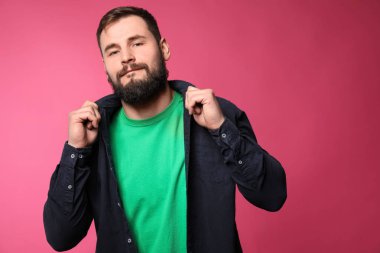 Renk arka plan üzerinde rahat kıyafetler içinde sakallı adam