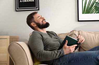 Sakallı adam evde kitap okuma