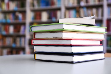 Kütüphanedeki masanın üzerinde kitap yığını
