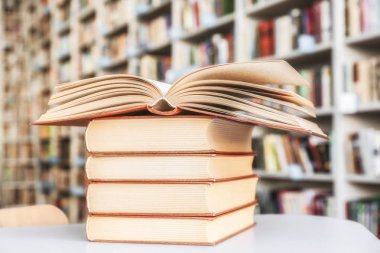 Kütüphanedeki masanın üzerinde kitap yığını