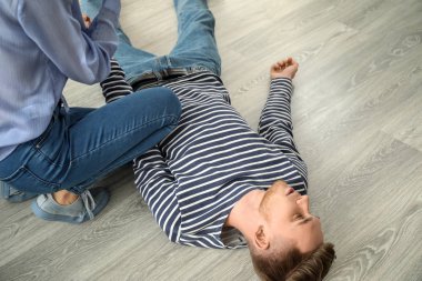 Kadın evde bilinçsiz kocası için ilk yardım sağlama