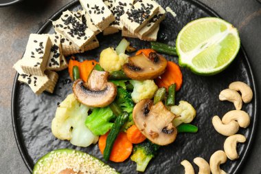 Lezzetli soya peyniri ve sebze gri tablo ile plaka