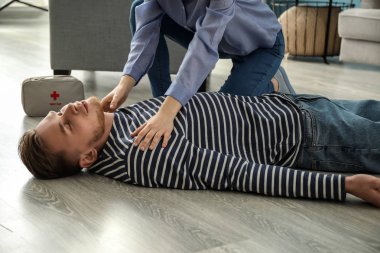 Kadın evde bilinçsiz kocası için ilk yardım sağlama