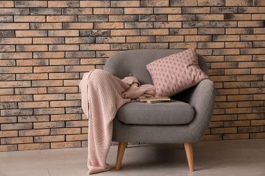 Tuğla duvarın yanındaki rahat koltuk