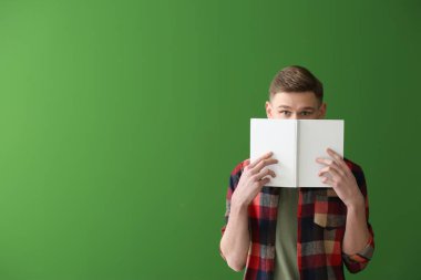 Renk arka plan üzerinde kitapla yakışıklı genç