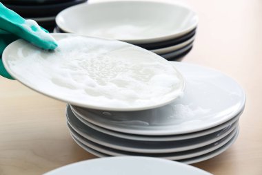 Kadın mutfakta bulaşık yıkıyor.