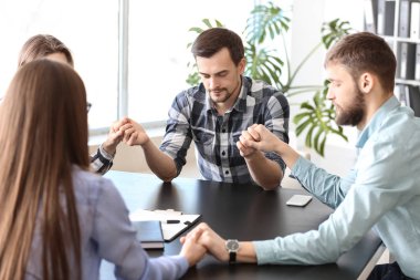 Bir grup insan office toplantıda önce dua