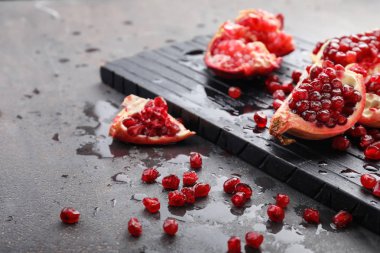 Ahşap tahta ve gri arka plan üzerinde olgun nar parçaları