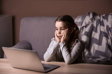 Akşamları çizgi film izlerken laptop ile sevimli küçük kız