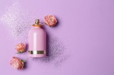 Renkli arka planda bir şişe parfüm ve çiçekler