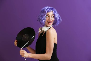 Vinil disk ve renk arka plan üzerinde kulaklık olan güzel kadın