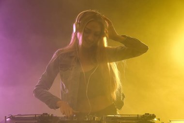 Kulüpte müzik çalan kadın DJ.