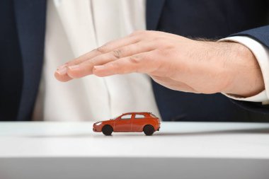 Oyuncak araba, closeup kapsayan sigorta acentası el. Özellik sigorta kavramı
