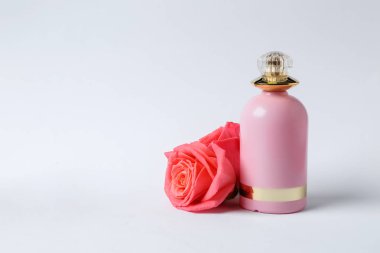 -Bir şişe parfüm ve beyaz arka plan üzerinde çiçekler