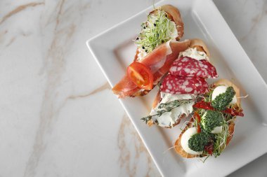 Plaka üzerinde açık renkli taze lezzetli bruschettas ile