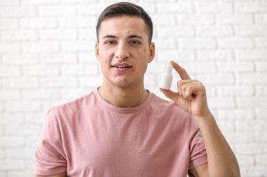 Beyaz duvara karşı Akne için ilaç ile genç adam portresi