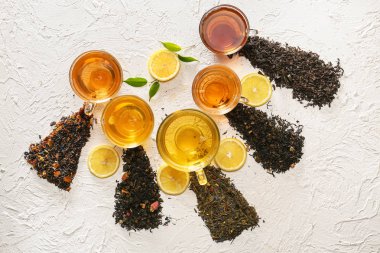 Bardak çay ve kuru farklı türleriyle yaprakları beyaz arka plan üzerinde