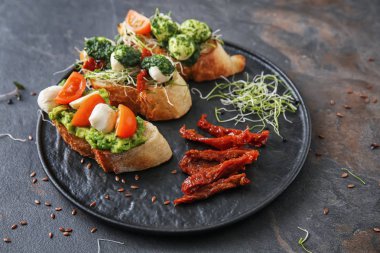 Plaka gri arka plan üzerinde taze lezzetli bruschettas ile