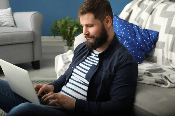 Bearded man working on laptop at home