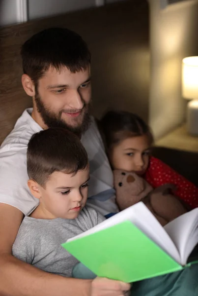 Молодой Отец Читает Книгу Своих Детей Постели — стоковое фото