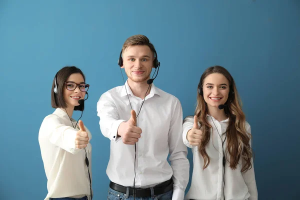 Team of technical support agents showing thumb-up on color background