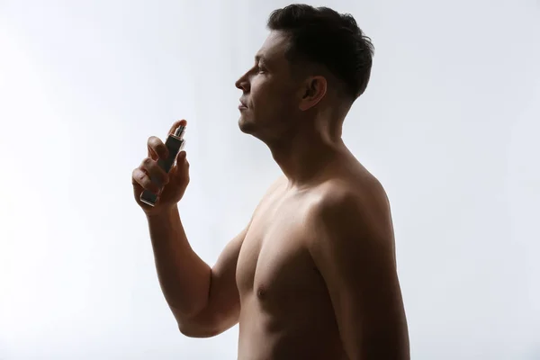 Knappe Man Met Fles Parfum Lichte Achtergrond — Stockfoto