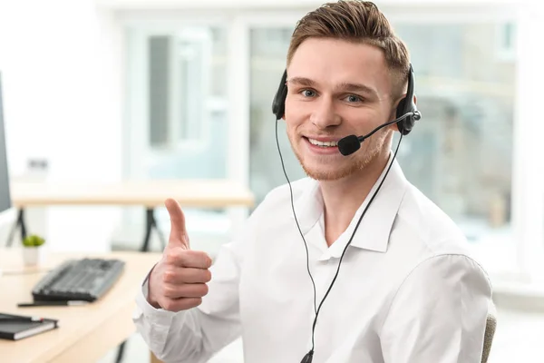 Portrait of male technical support agent showing thumb-up in office