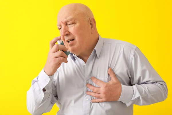 Äldre Man Med Inhalatorn Astma Attack Mot Färg Bakgrunden — Stockfoto