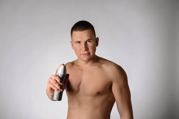 Pohledný Mladý Muž Deodorant Šedém Pozadí — Stock fotografie