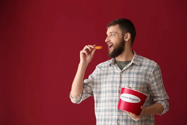 Hombre Guapo Con Cubo Sabrosas Pepitas Sobre Fondo Color —  Fotos de Stock