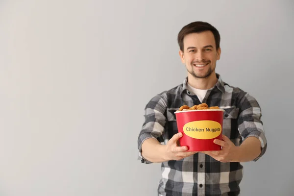 Hombre Guapo Con Cubo Sabrosas Pepitas Sobre Fondo Claro —  Fotos de Stock