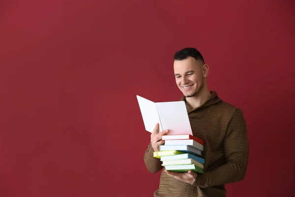 Joven Guapo Con Libros Sobre Fondo Color —  Fotos de Stock