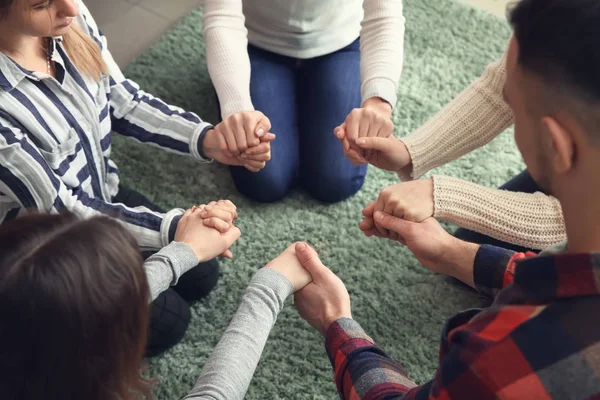 Group of people praying together indoors