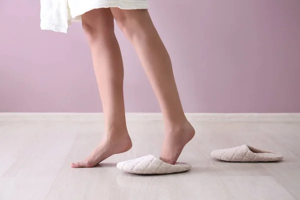 Young woman walking on tiptoe without slippers at home