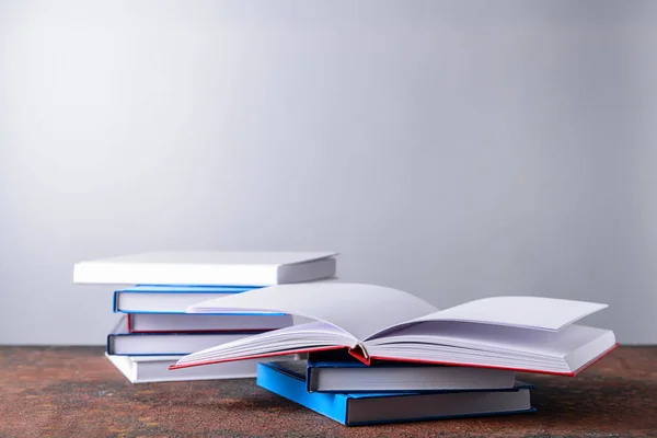 Molti Libri Sul Tavolo Contro Sfondo Grigio — Foto Stock