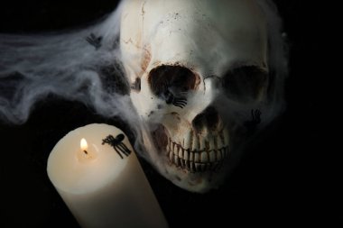 Örümcek ağı ve koyu arka plan üzerine de mum ile insan kafatası