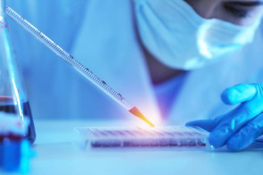 Bilim adamı laboratuvarda çalışan damlalık ile