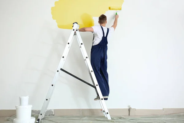 Male Decorator Using Roller Painting Wall Indoors — Stock Photo, Image