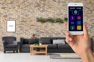 Akıllı ev otomasyon uygulaması ile cep telefonu tutan kadın