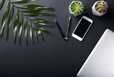 Dizüstü bilgisayar ve cep telefonu koyu arka plan üzerinde şık işyeri