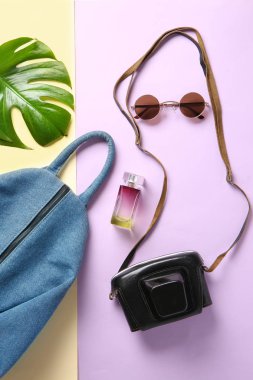 Sırt çantası, fotoğraf makinesi ve kadın aksesuarları renk arka plan üzerinde düz yatıyordu kompozisyonu