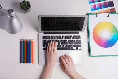 Laptop ile beyaz arka plan üzerinde çalışan kadın grafik tasarımcı